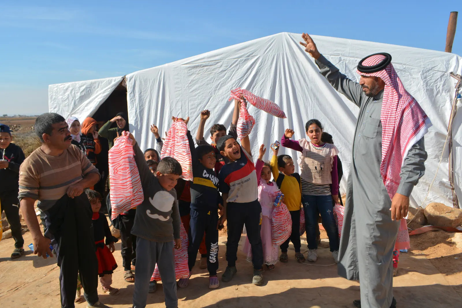 Children gathering outside a tent in Mafraq